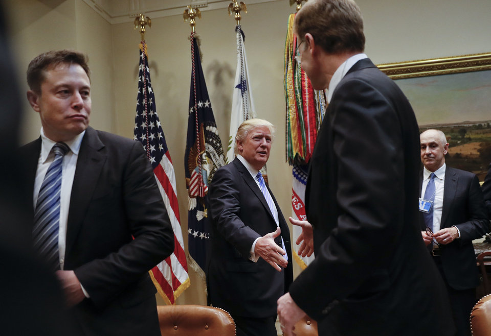 President Donald Trump greets Wendell P. Weeks, right, Chief Executive Officer of Corning, as he host breakfast with business leaders in the Roosevelt Room of the White House in Washington, Monday, Jan. 23, 2017. On the left of is Elon Musk, CEO of SpaceX and Tesla Motors. (AP Photo/Pablo Martinez Monsivais)