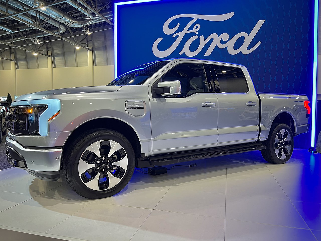 ford f-150 lightning in front of ford logo