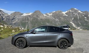 tesla model y in front of mountain range